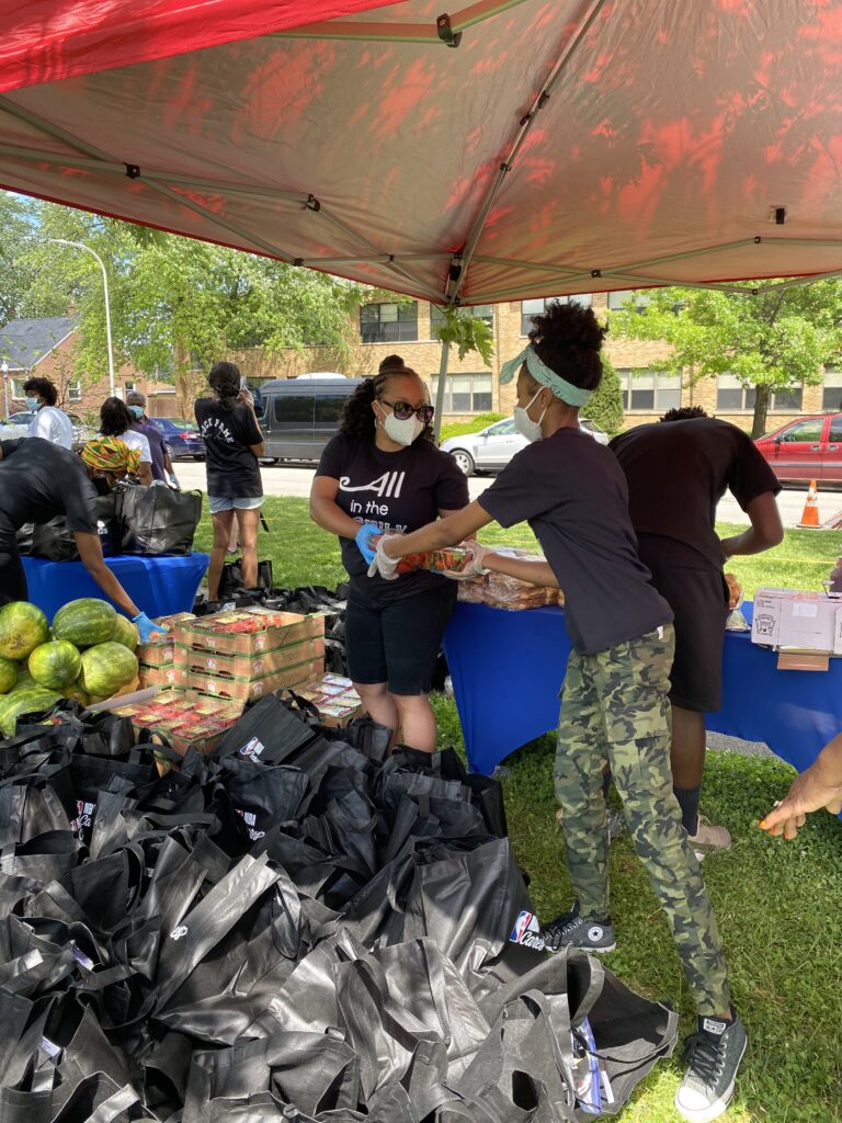 Two social works volunteers working together to distribute food. 